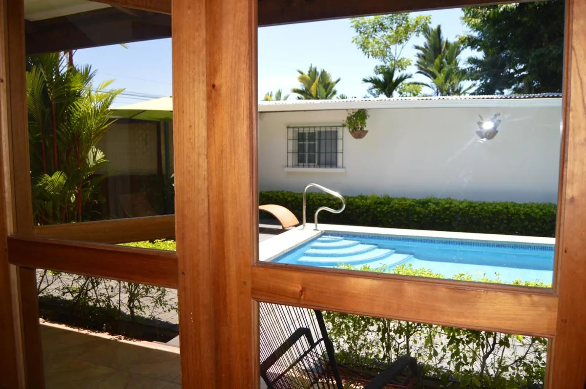 La piscina vista a través del marco de madera del corredor.
